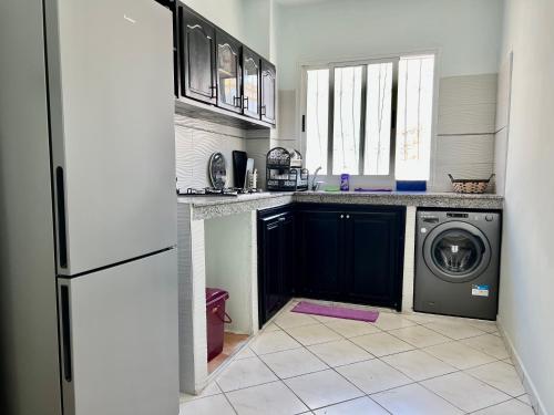 a kitchen with a washer and a washing machine in it at Cozy Apartment in Salam center in Agadir