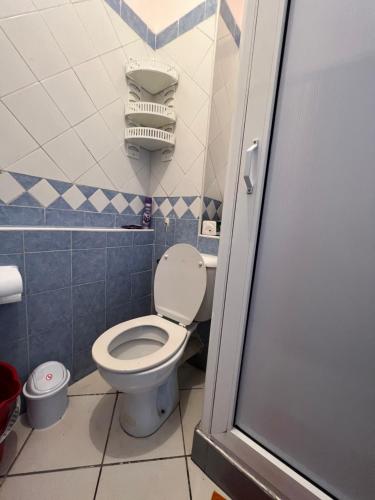 a bathroom with a toilet with a blue and white tiles at Cozy Apartment in Salam center in Agadir