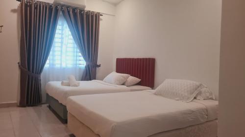 two beds in a room with blue curtains and a window at Anjung KLIA House 31 With Neflix & Airport Shuttle in Banting