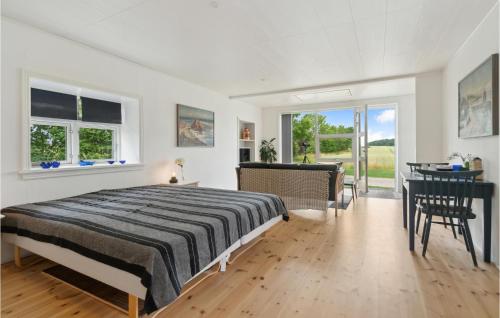 a bedroom with a bed and a table and chairs at 1 Bedroom Amazing Apartment In Rnne in Rønne