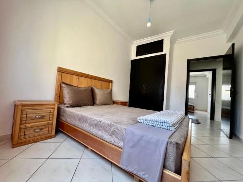 1 dormitorio con 1 cama y vestidor en una habitación en Cozy Apartment in Salam center, en Agadir