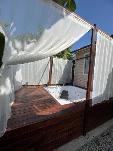 a deck with a tub and a white curtain at Kiriş Garden Hotel in Kemer