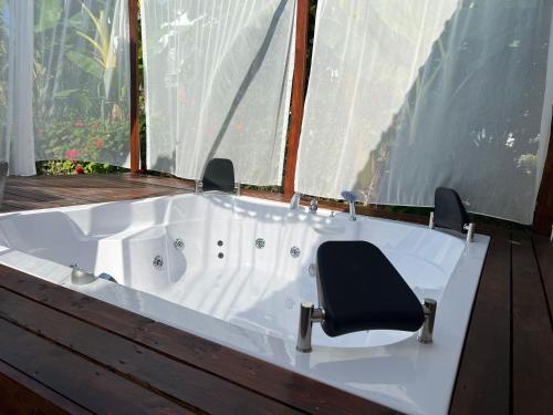 a white bath tub with a chair in a room at Kiriş Garden Hotel in Kemer