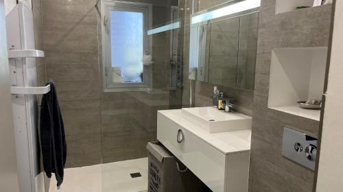 une salle de bain avec un lavabo et un miroir dans l'établissement Le Rocher Des Sanguinaires, à Ajaccio