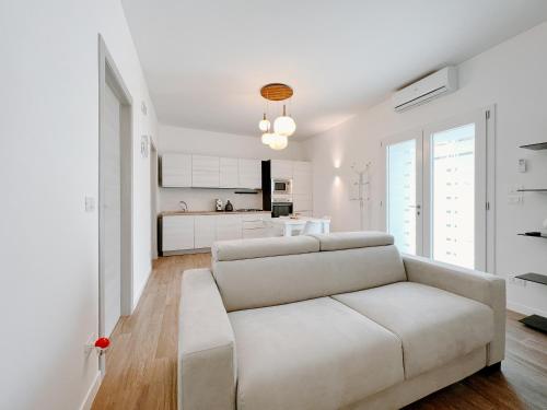 a white living room with a couch and a kitchen at Villa Angelica - Casa Vacanze in Reggio di Calabria