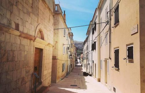 an empty alley with buildings in an old town at Rooms & studio OLD TOWN PAG in Pag