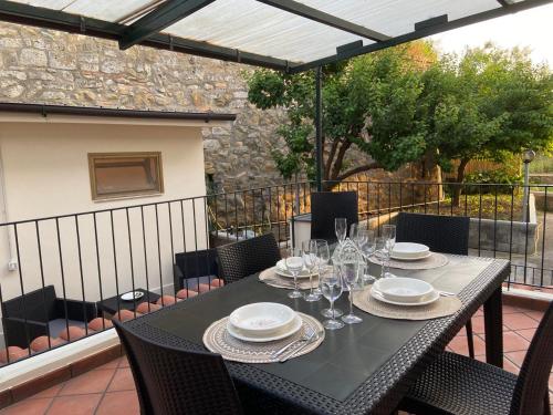 a table with wine glasses and plates on a patio at Casa di Nonna Gilda in Massa Lubrense