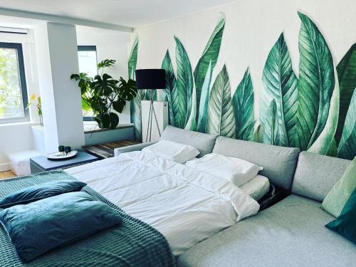 a bedroom with a bed and a mural of leaves at Sfeervolle vakantiewoning aan zee in Ostend