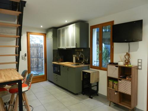 une cuisine avec des armoires vertes et un évier dans l'établissement La Petite Maison, à Ceyreste