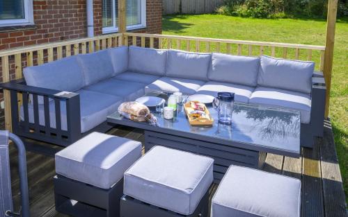 a blue couch on a deck with a table and chairs at APPLEDOWN - Secluded Rural Retreat in Kingsdown, 10 mins to BEACH in Kent