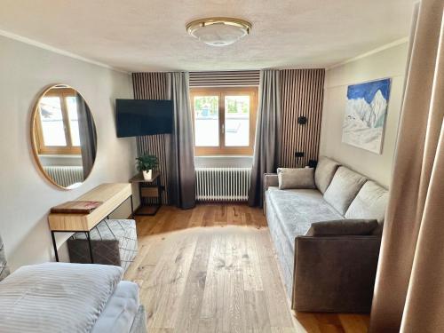 a living room with a couch and a mirror at Haus Schrofenstein in Lech am Arlberg