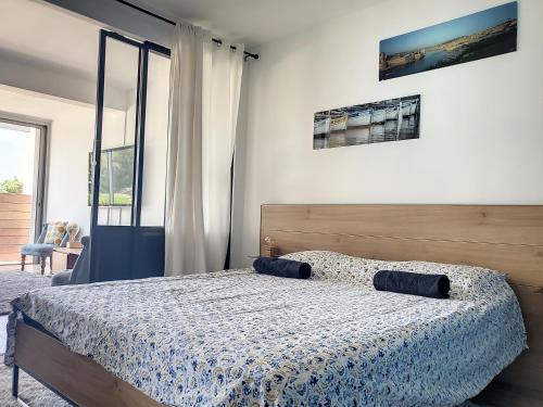 a bedroom with a bed with a blue and white comforter at Le Grand Large, face à vous in Cassis