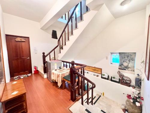 a room with a staircase with a table in it at 旭緣咖啡民宿 in Taitung City
