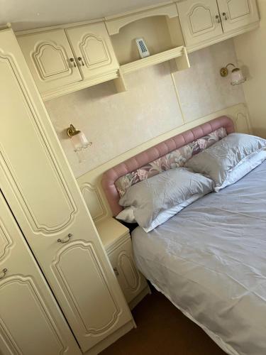 a bedroom with a bed with a pink headboard at Caravan 13 Stonehaven recreation grounds in Stonehaven