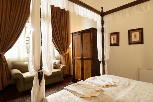a bedroom with a canopy bed and a chair at Mansion Alcazar in Cuenca
