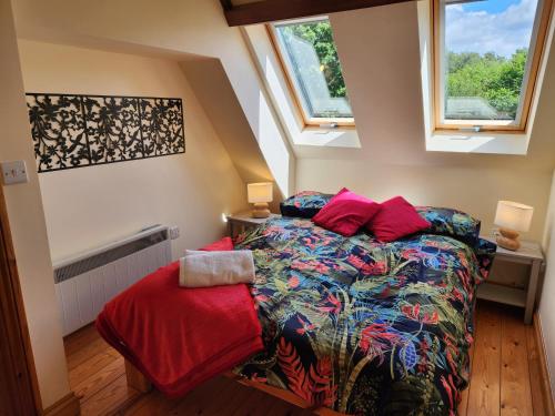 a small bedroom with a bed and two windows at The Old School Caeathro, Snowdon, Eryri and Yr Wydffa Cottages in Caernarfon