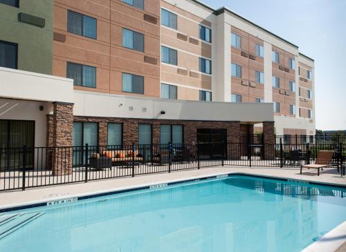 a swimming pool in front of a building at Courtyard by Marriott Houston NASA Clear Lake in Nassau Bay
