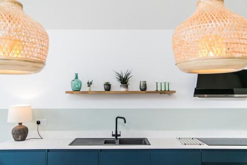 a kitchen with two light fixtures and a sink at Saltwhistle - Bracklesham Bay in Chichester