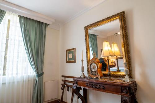 a room with a mirror and a table with a clock at Mansion Alcazar in Cuenca