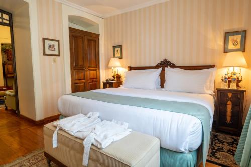 a hotel room with two beds with towels on a bench at Mansion Alcazar in Cuenca