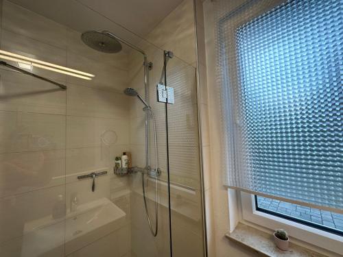 a bathroom with a shower and a tub and a window at Traumhafte Haushälfte mit Kamin, Garten & Whirlpool in Berlin