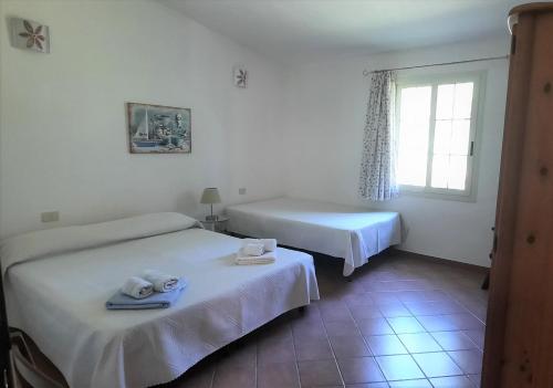 a hotel room with two beds and a window at MaLù House in Villasimius