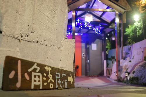 a sign on the side of a building with christmas lights at Corner Inn九份住宿I 小角落民宿I 機車租借I日夜間導覽 in Jiufen