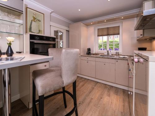 a kitchen with a counter and a chair in it at Südwind´s Friesenlodge in Tinnum