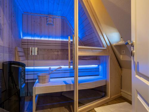 提努姆的住宿－Südwind´s Friesenlodge，一间小房间中带蓝色灯光的桑拿浴室