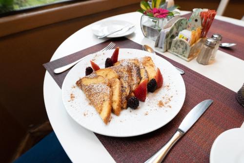a white plate with cake and berries on a table at Mansion Alcazar in Cuenca