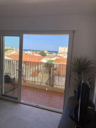 d'une porte coulissante en verre avec vue sur un balcon. dans l'établissement Cap au sud !, à Narbonne-Plage