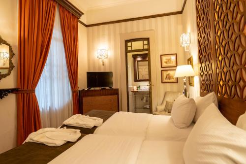 a hotel room with two beds and a television at Mansion Alcazar in Cuenca