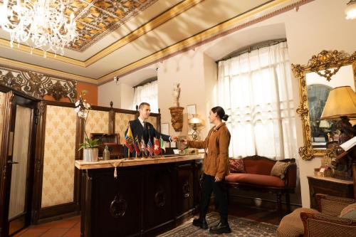 a man and a woman shaking hands at a bar at Mansion Alcazar in Cuenca