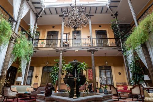 a fountain in the middle of a building with a chandelier at Mansion Alcazar in Cuenca