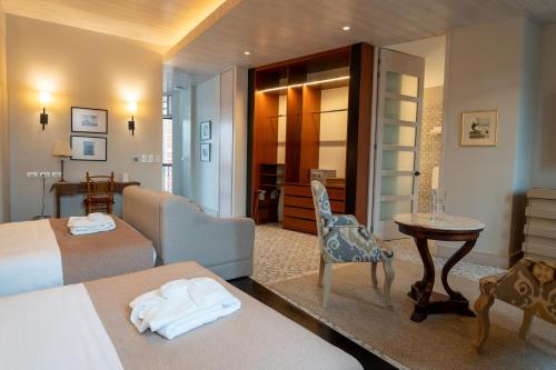 a hotel room with two beds and a table at Mansion Alcazar in Cuenca