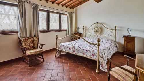 Schlafzimmer mit einem Bett, einem Stuhl und Fenstern in der Unterkunft Il Solatio in Cavriglia