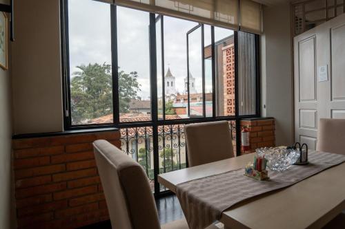 a dining room with a table and a large window at Mansion Alcazar in Cuenca