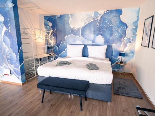 a bedroom with a large bed with a blue wall at City Loft - 5 Min Rhein-Galerie in Ludwigshafen am Rhein