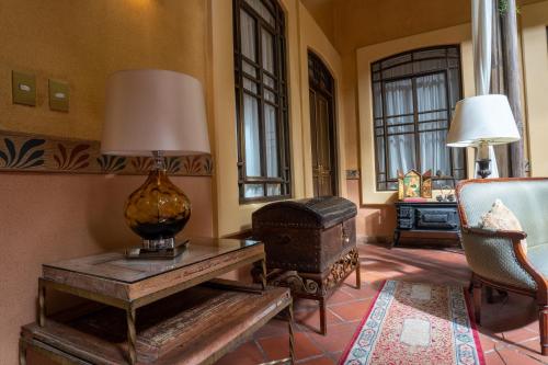 a living room with a table and a lamp and a chair at Mansion Alcazar in Cuenca