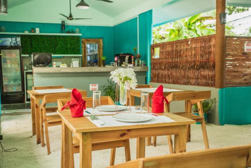 ein Esszimmer mit Holztischen und roten Bögen in der Unterkunft Palm Rest Maldives in Magoodhoo