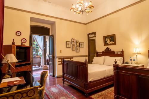 a bedroom with a bed and a desk and a television at Mansion Alcazar in Cuenca