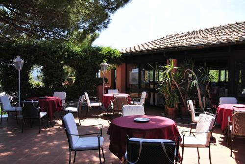 a group of tables and chairs with red and white tables at Resort Le Picchiaie in Portoferraio