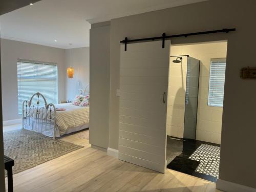 a bedroom with a bed and a door leading into a room at Metanoia Kingswood Golf Estate in George