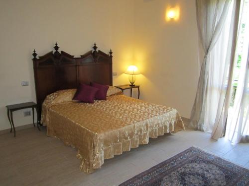 a bedroom with a bed with a wooden head board at B&B Al Calcandola in Sarzana