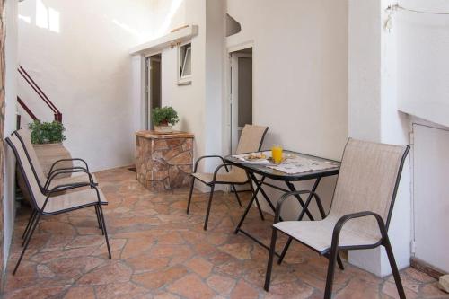 a patio with a table and chairs in a room at Nikos apartment - Lakka Paxos in Lákka