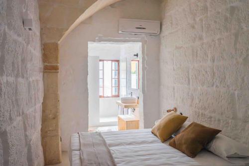 a bedroom with a bed in a brick wall at Pere Alcantara 40, 3 bedroom house, Ciutadella in Ciutadella
