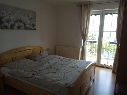a bedroom with a bed and a large window at NATALIJA - holiday house with garage in Sveti Juraj