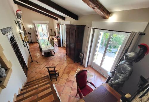 einen Blick über ein Wohnzimmer mit einer Treppe und ein Zimmer mit einem Kamin in der Unterkunft "La Massette du Cheval Blanc" Villa de caractère en pierre in LʼIsle-sur-la-Sorgue