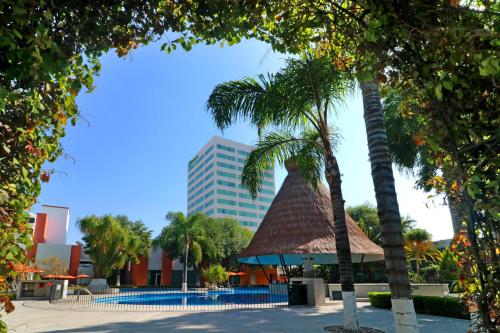 a resort with palm trees and a swimming pool at Holiday Inn San Luis Potosi-Quijote by IHG in San Luis Potosí