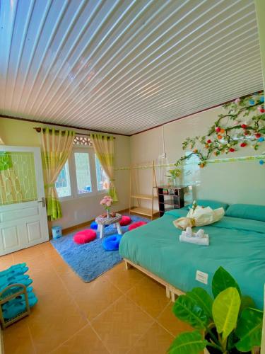 a bedroom with a green bed with a white ceiling at Rose's House in Khu Chi Lăng